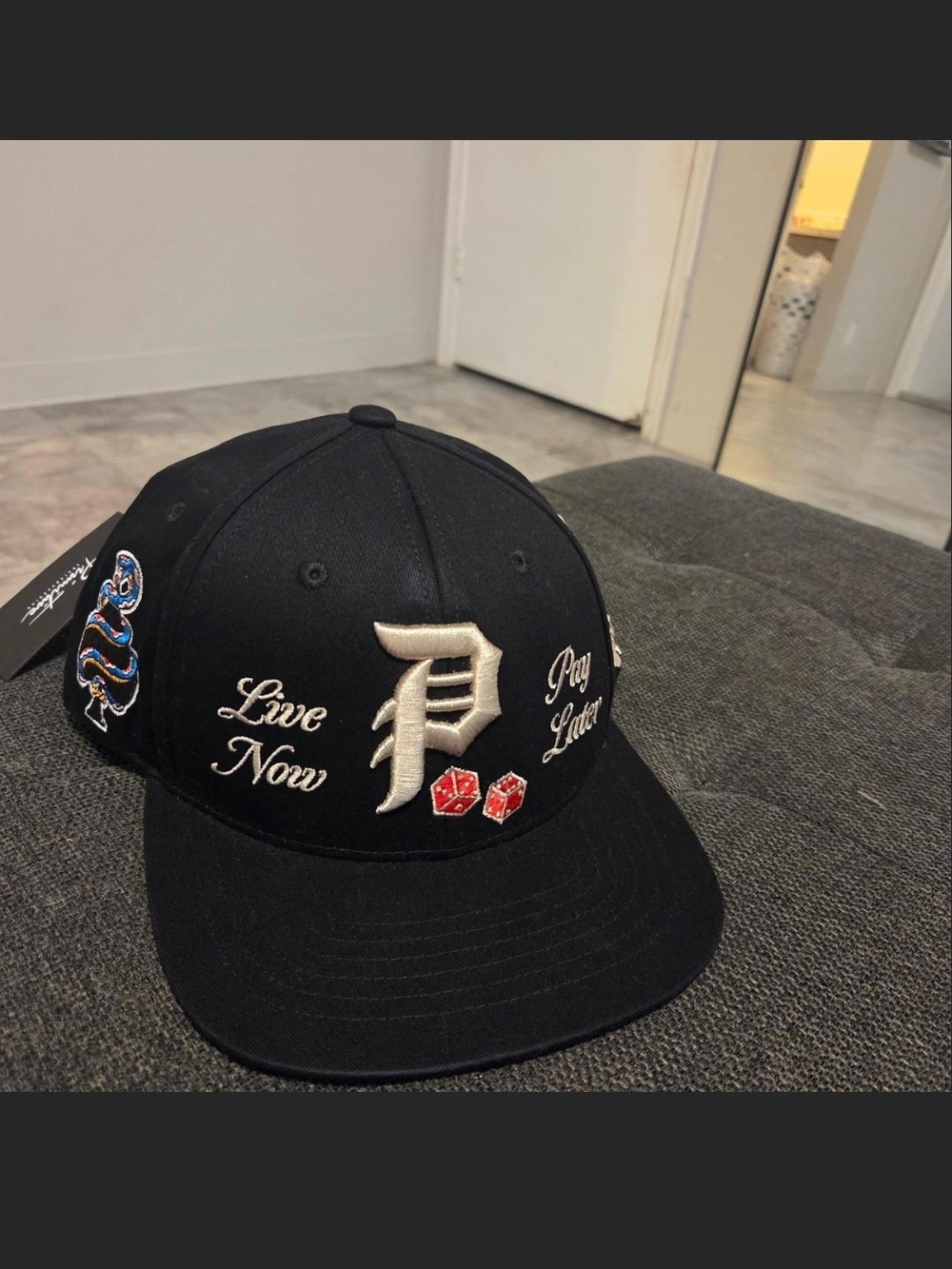 Primitive Black Snapback Hat with Cream Embroidered 'P' and Red Dice